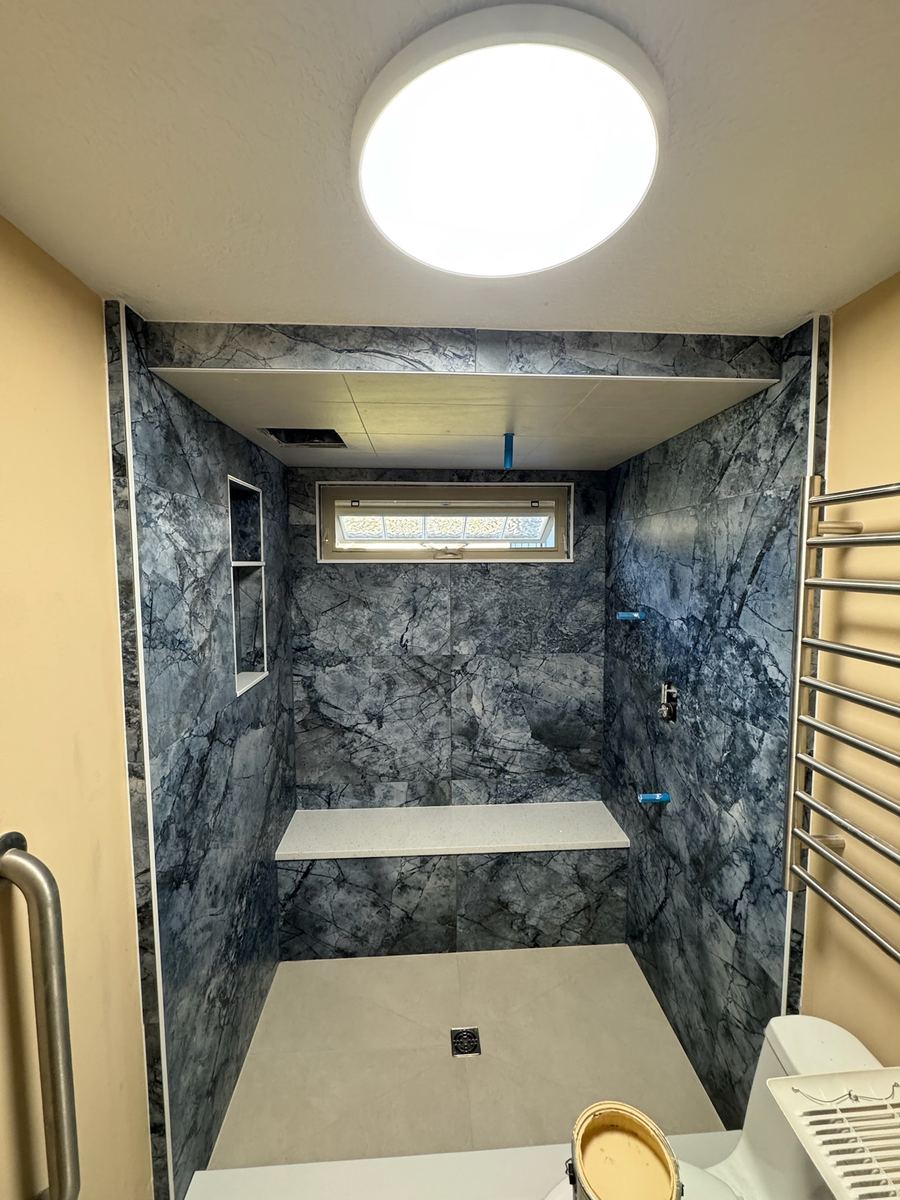 Large format eccentric blue tile, master bathroom shower remodel, with envelope-cut LFT on shower floor, St. Augustine FL